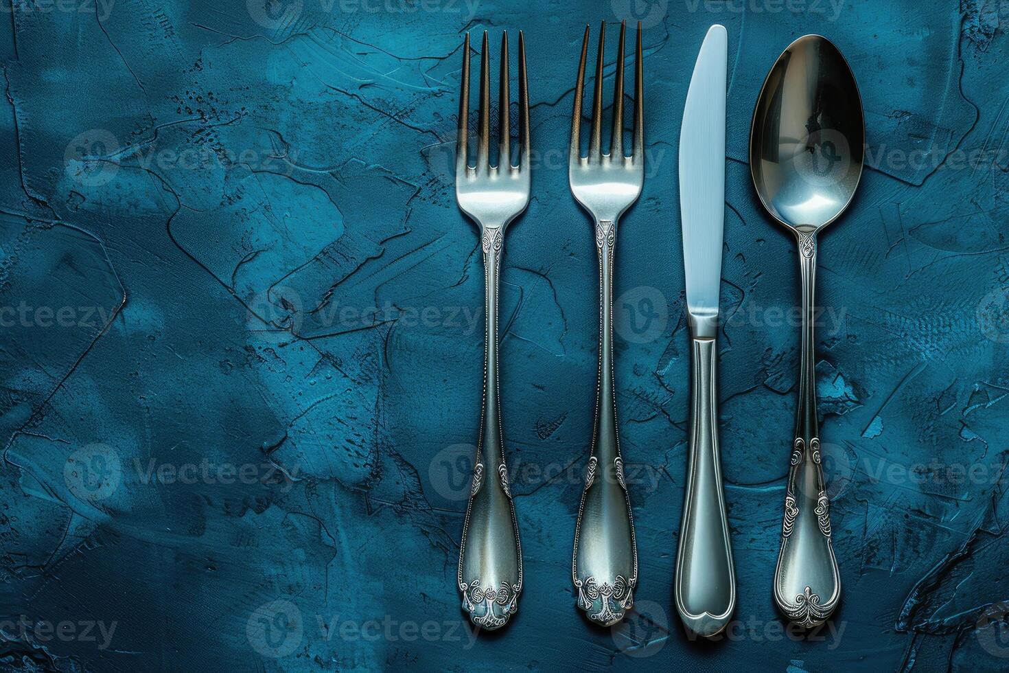 Elegant Silverware Set on a Teal Textured Background photo