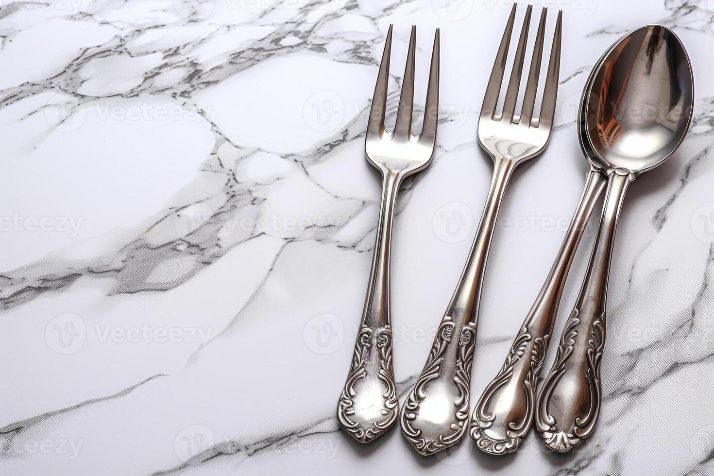 Two Silver Forks and a Spoon on Marble Surface photo