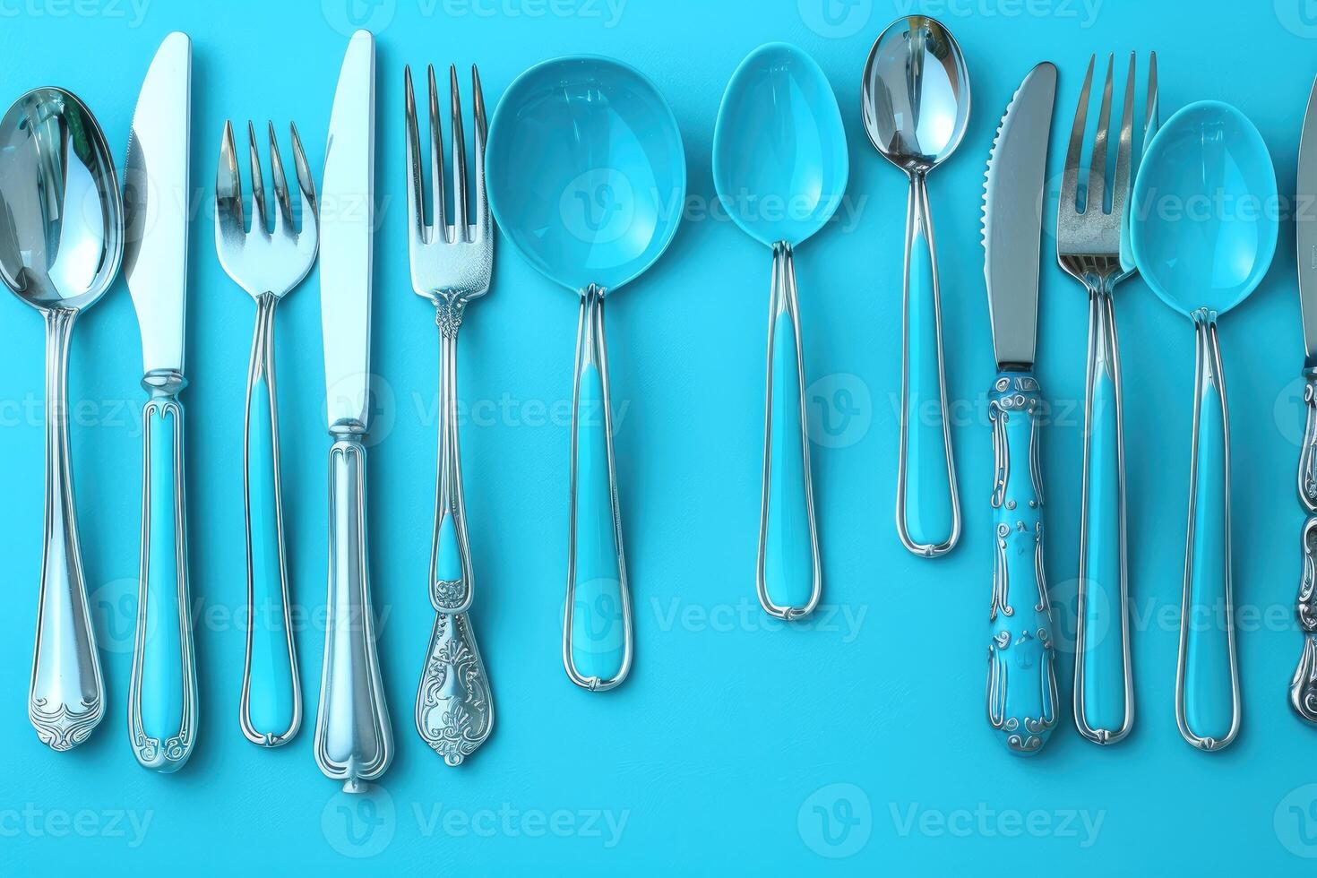 Silverware with Blue Handles on a Turquoise Background photo