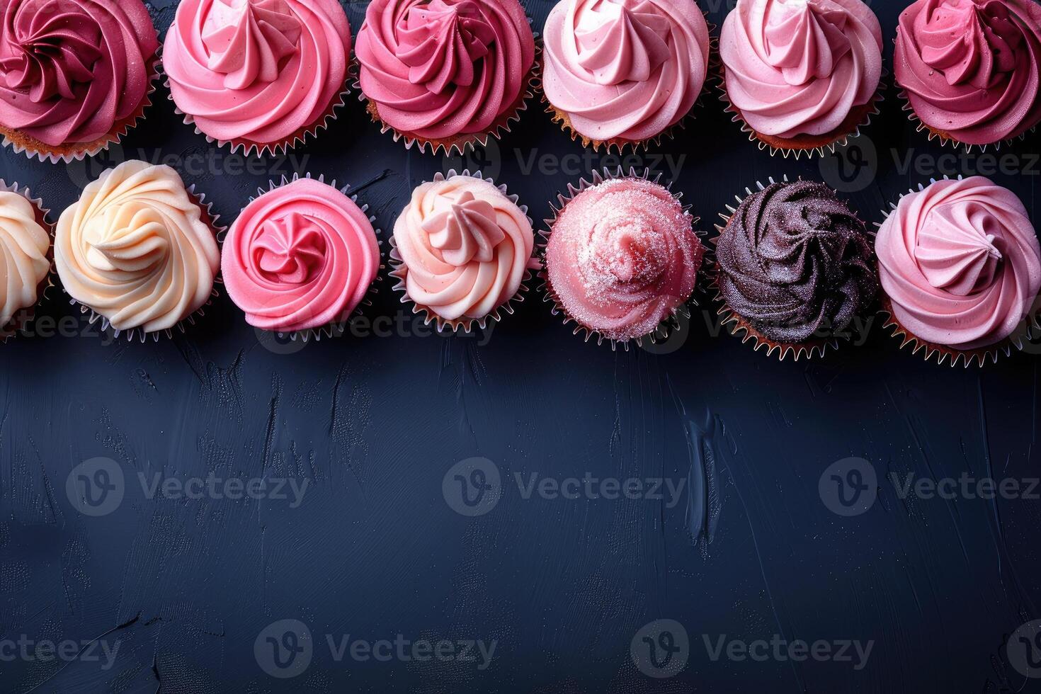 A row of colorful cupcakes arranged on a dark blue surface creating a festive and tempting display photo