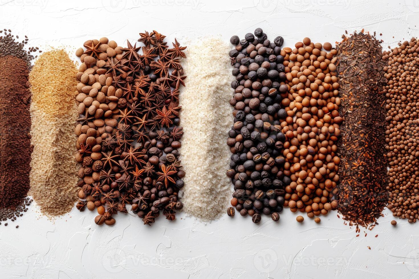 Various types of seeds nuts and spices arranged in separate piles on a white surface photo