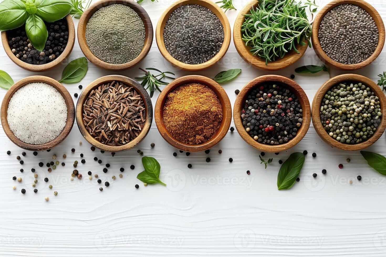 An assortment of colorful spices and dried herbs in wooden bowls on a whitewashed wooden background photo