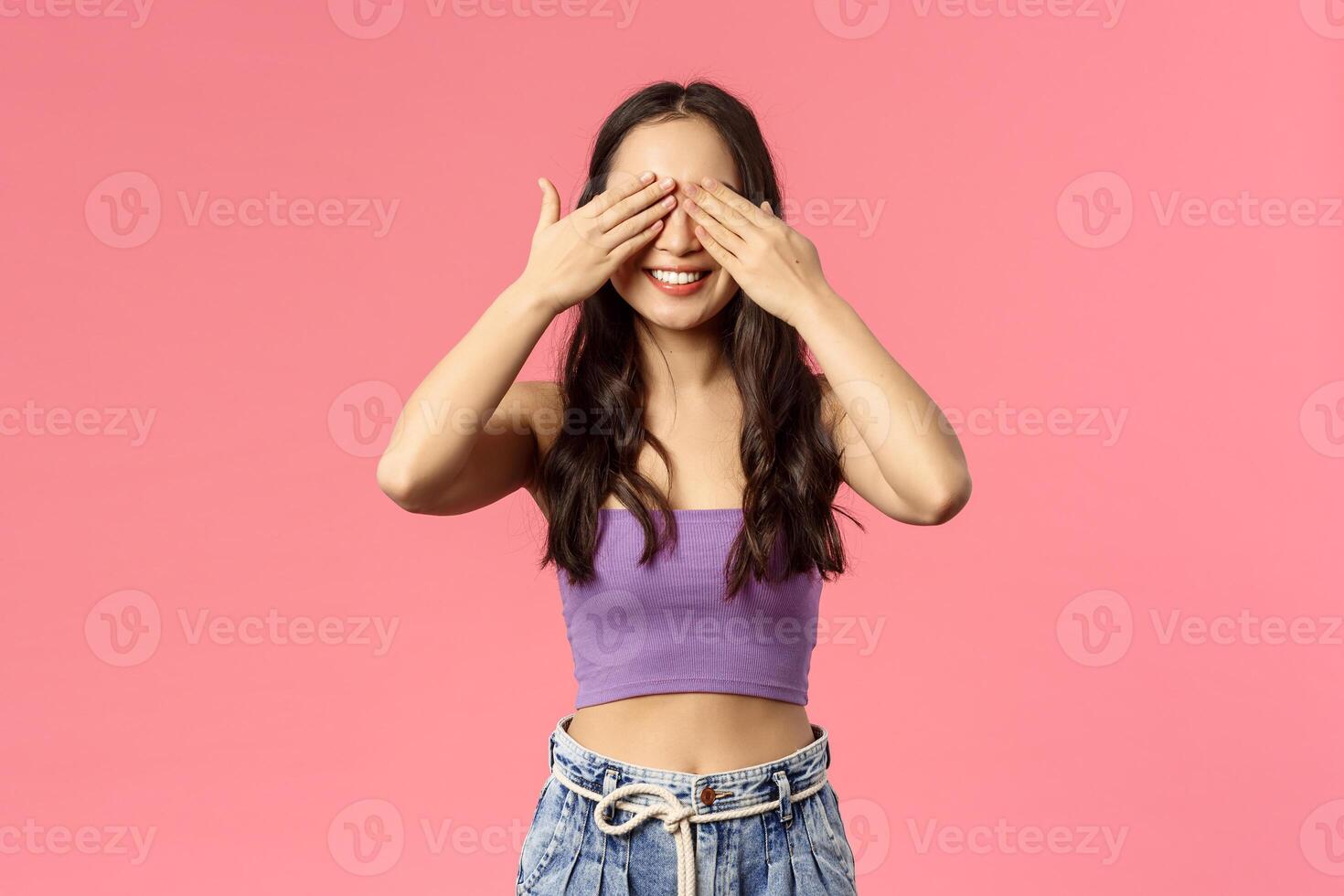 Promise not peek. Cheerful stylish young woman hanging around with friends, hold hands on closed eyes and smiling, anticipating surprise, awaiting for command look at gift, b-day party concept photo