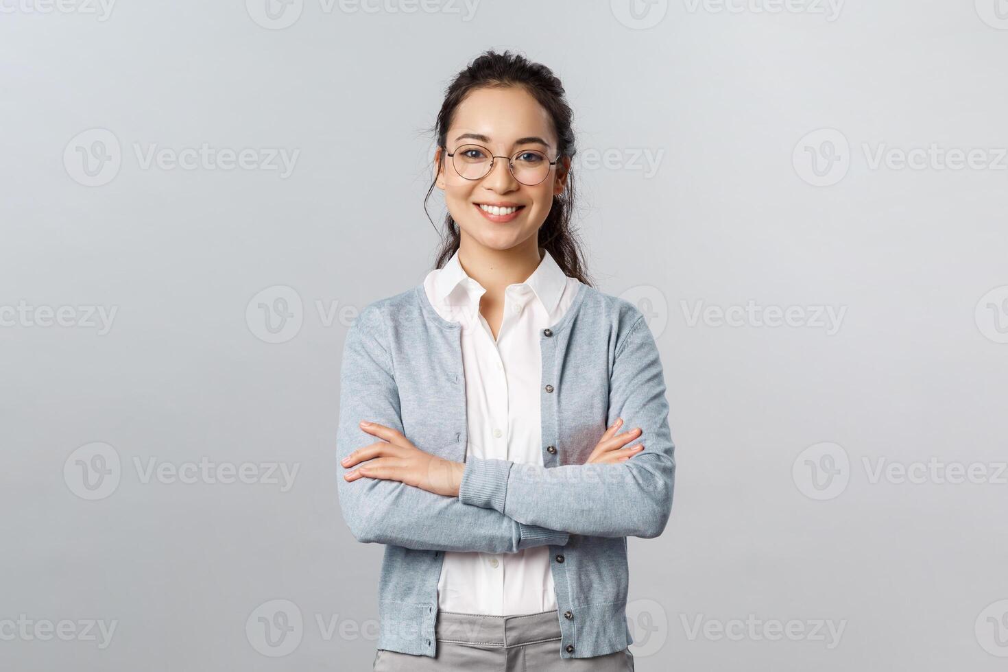 Career, business and education concept. Portrait of cheerful asian girl ready to start online lesson with students, explain class new theme, cross hands chest confident, smiling self-assured photo
