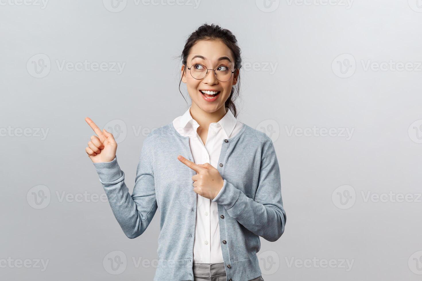 Education, studying and online classes concept. Impressed, happy attractive female entrepreneur in glasses, smiling wondered and amused, pointing looking upper left corner at advertisement photo