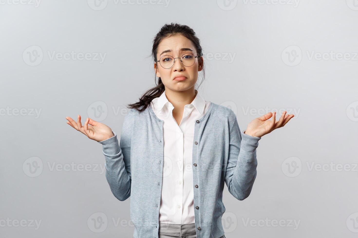 Well, we have nothing to do about it, cant deal problem. Portrait of indecisive or desperate asian woman shrugging and raise hands sideways perplexed, dont know cant tell, being clueless photo