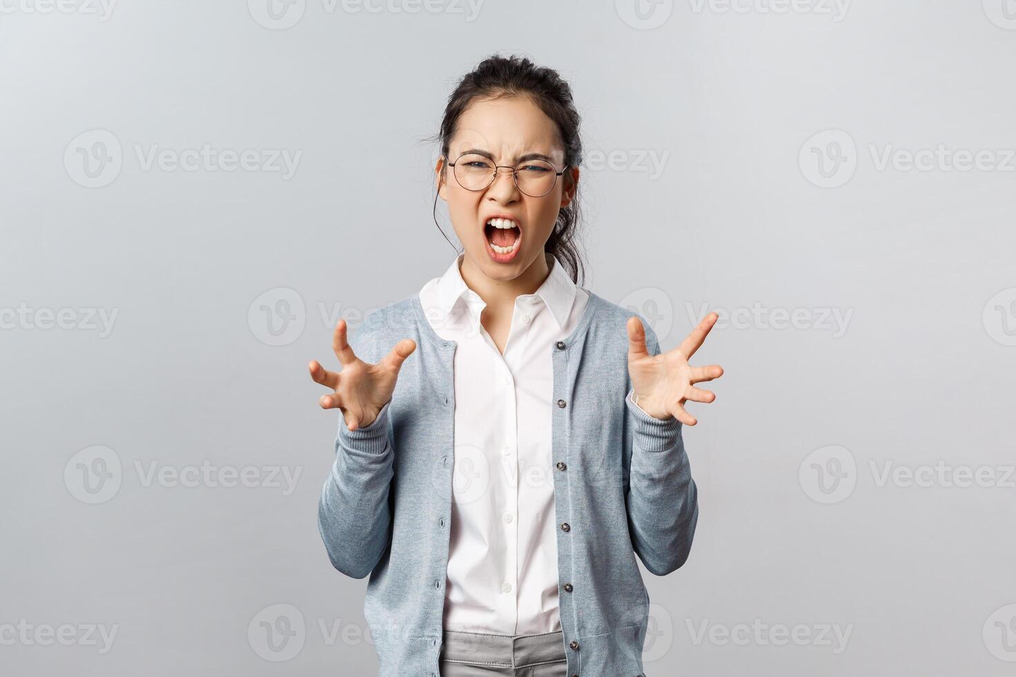 Emotions, people and lifestyle concept. Angry pissed-off, sick and tired asian woman in glasses shouting and clench hands into fists agressive, hate someone shouting with anger and rage photo