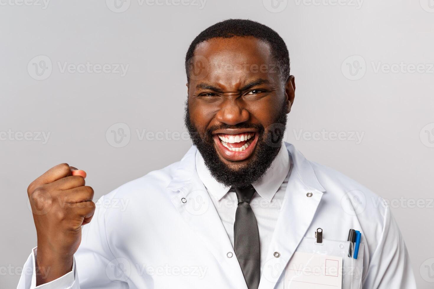 Healthcare, medicine and hospital treatment concept. Close-up portrait of triumphing, rejoicing african-american doctor finally fought disease got positive test results, fist pump and saying yes photo