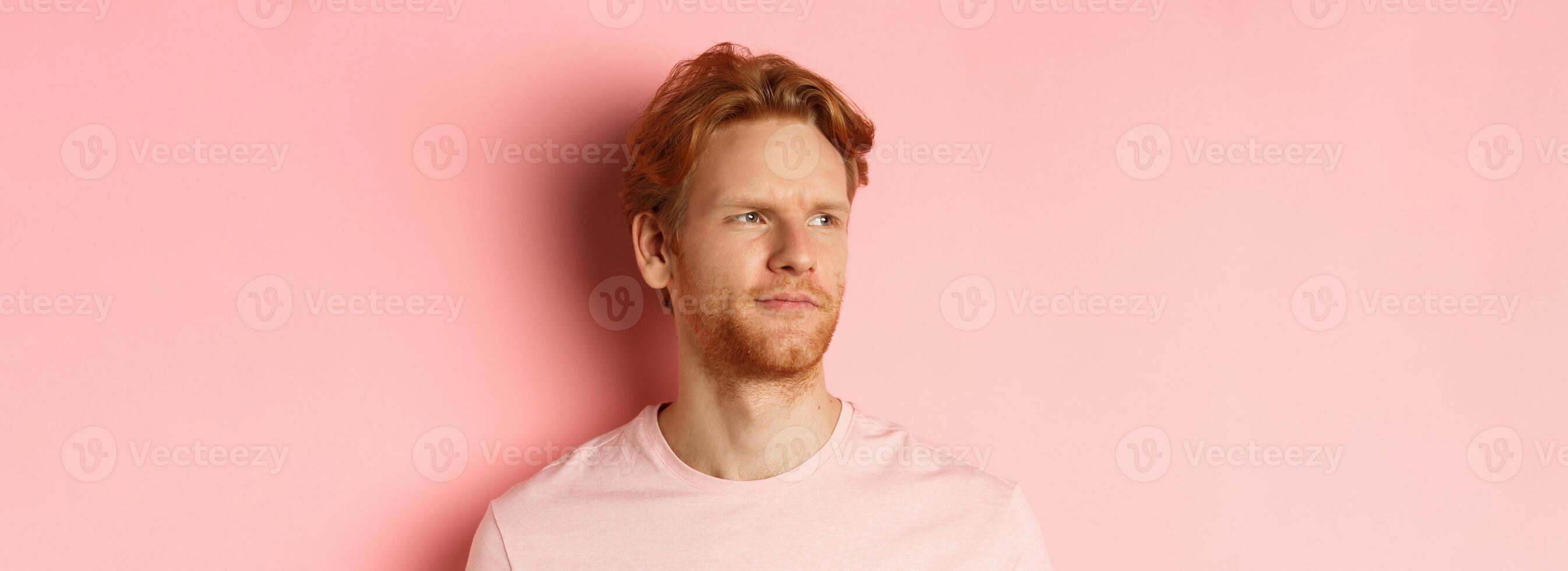 Close up of skeptical and unamused european man, smirk with judgemental face, looking left at banner, standing over pink background photo