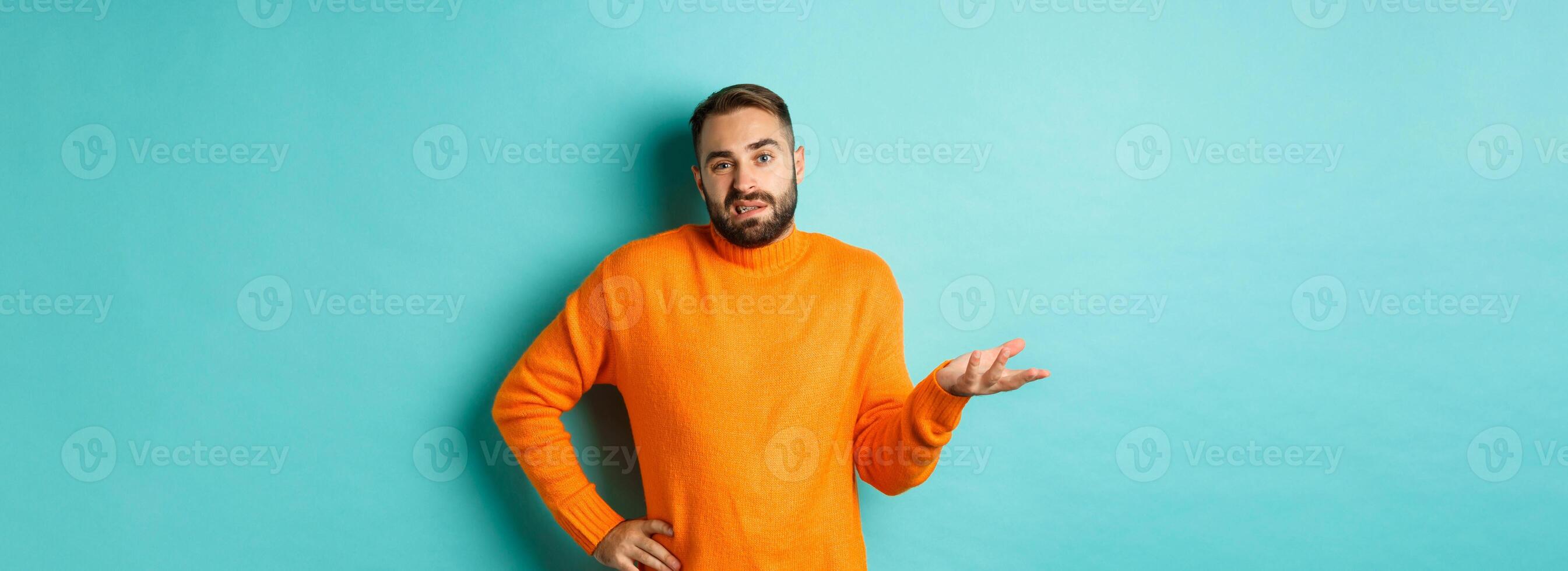Careless and indifferent guy shrugging, looking unbothered, dont know anything, standing over light blue background photo
