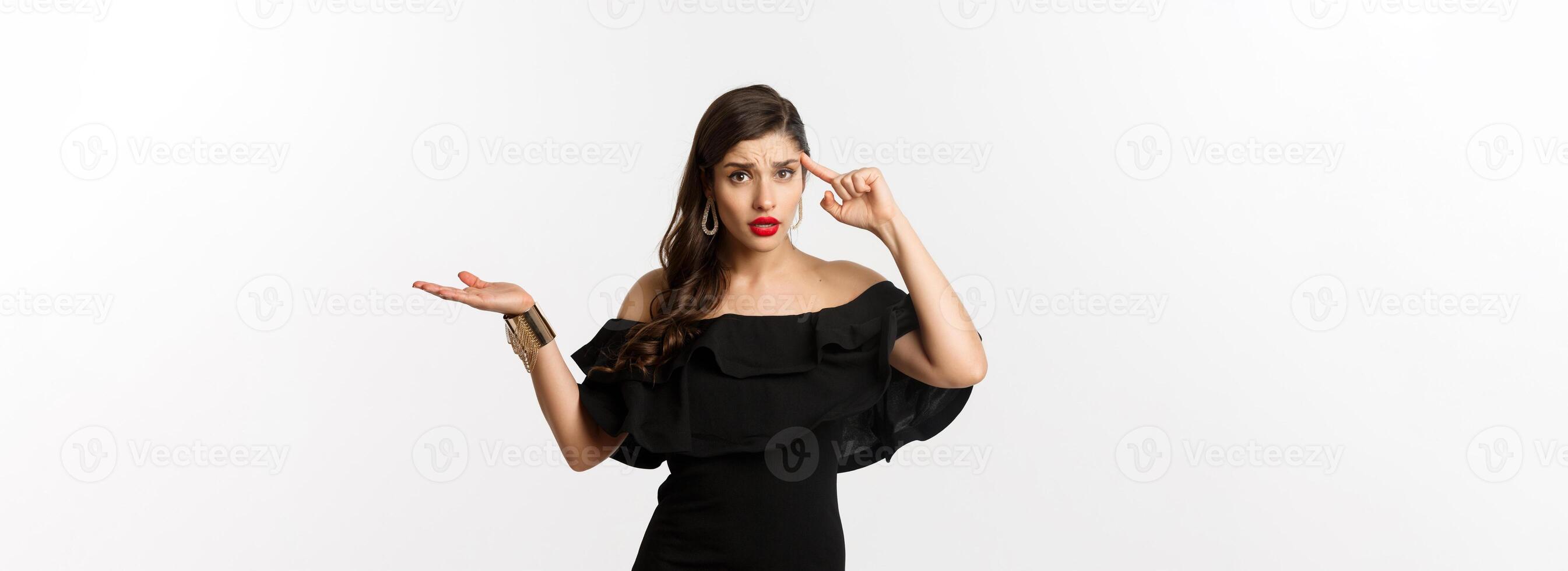 Fashion and beauty. Annoyed and bothered woman pointing at head, scolding someone for stupid mistake, looking confused, standing over white background photo
