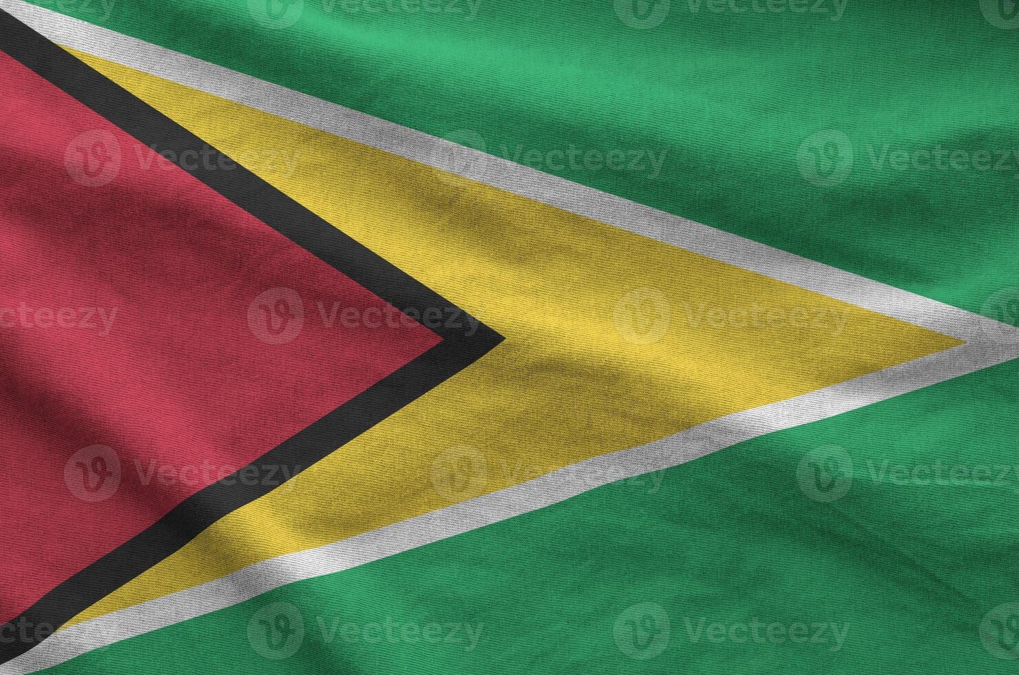 Guyana flag depicted on folded wavy fabric of old cloth photo