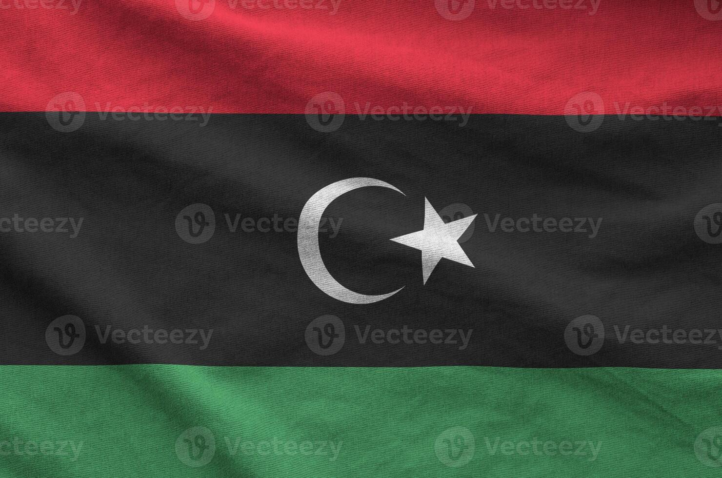 Libya flag depicted on folded wavy fabric of old cloth photo