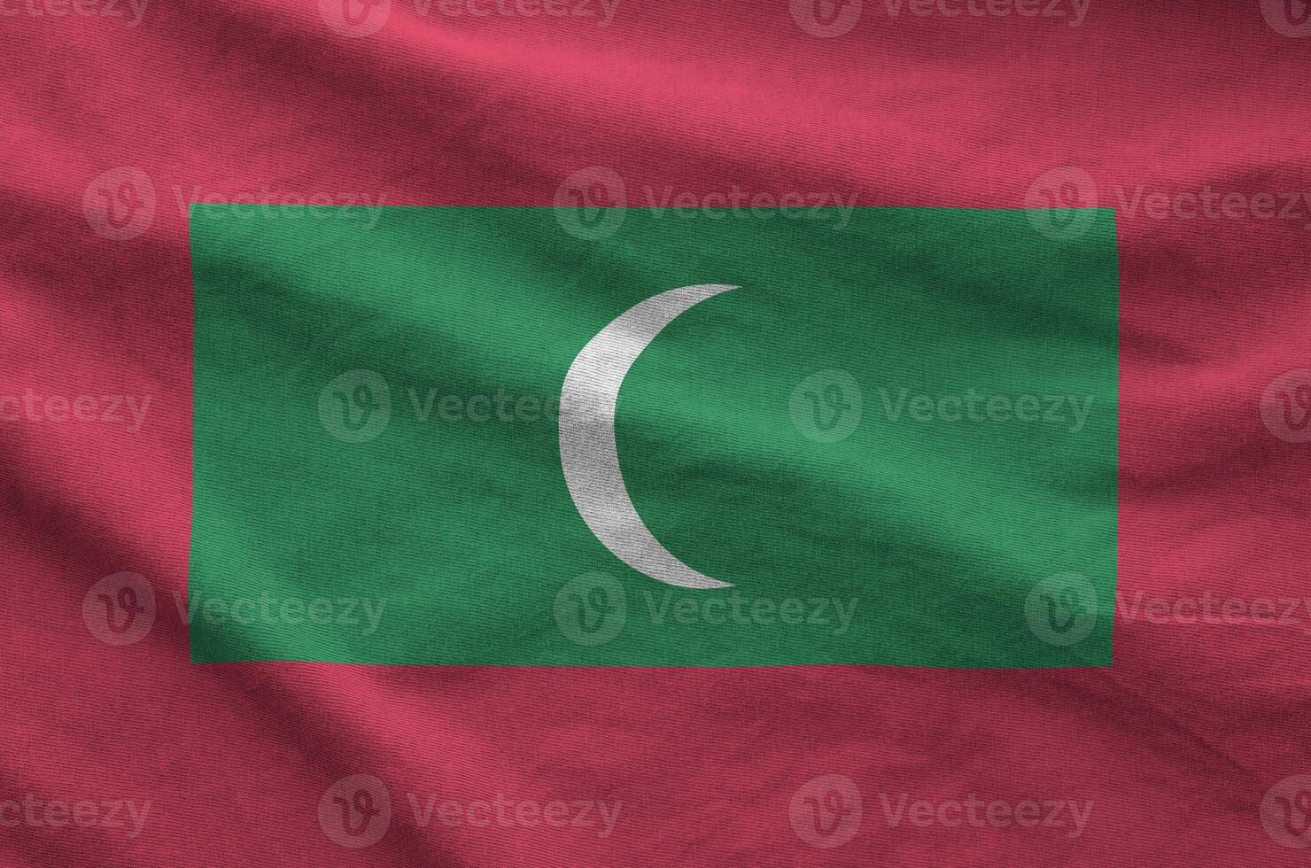 Maldives flag depicted on folded wavy fabric of old cloth photo