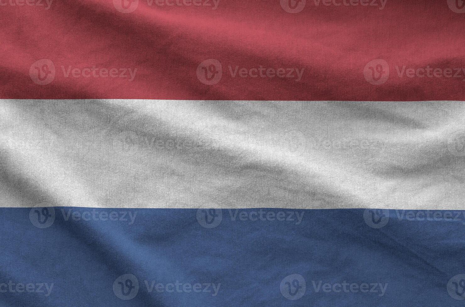 Netherlands flag depicted on folded wavy fabric of old cloth photo