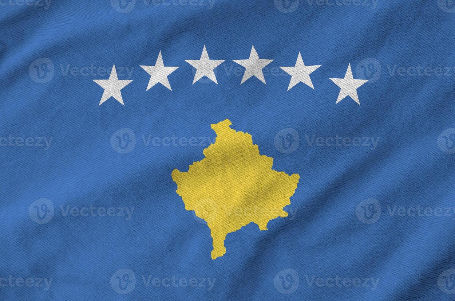 Kosovo flag depicted on folded wavy fabric of old cloth photo