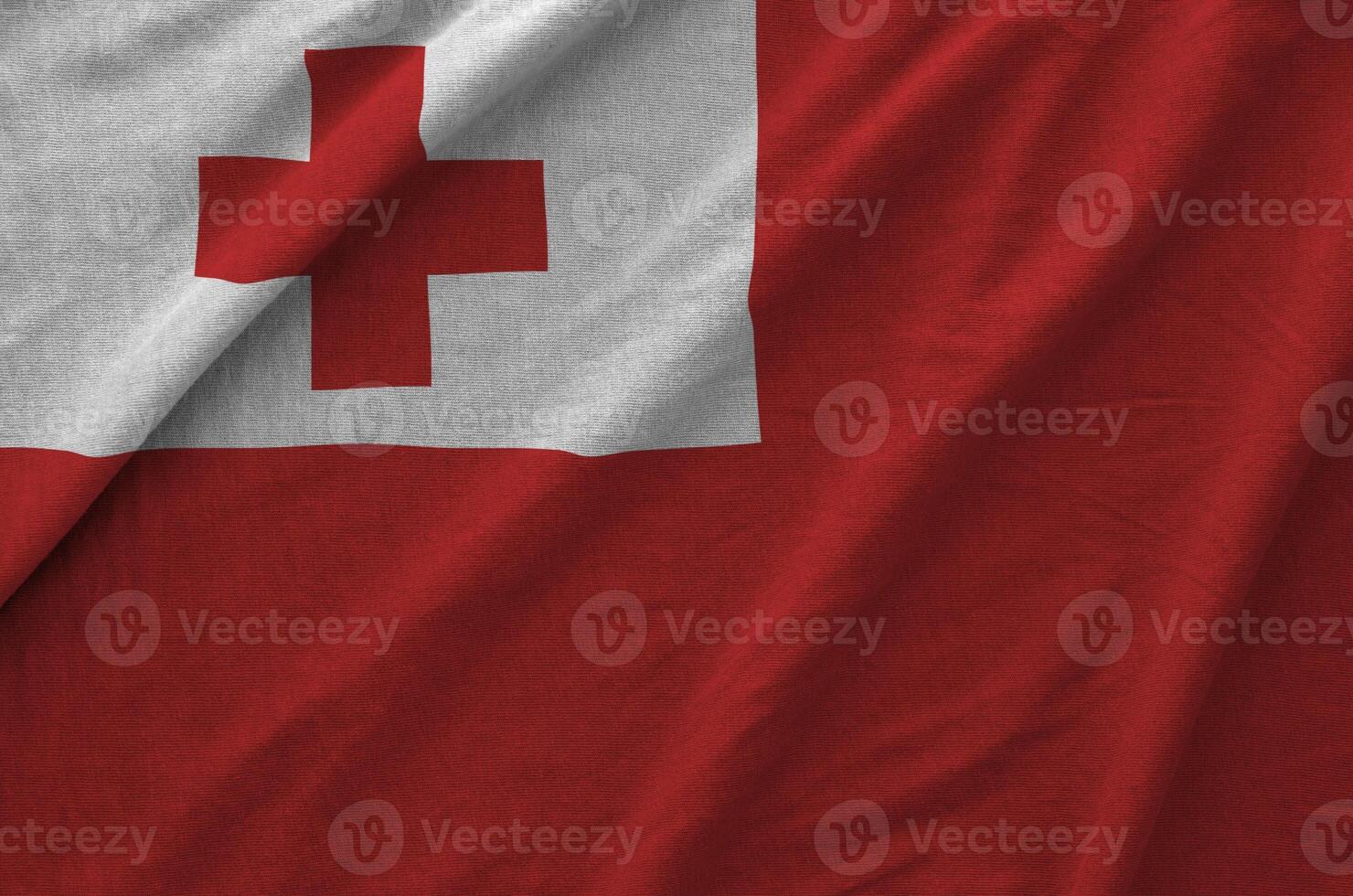 Tonga flag depicted on folded wavy fabric of old cloth photo