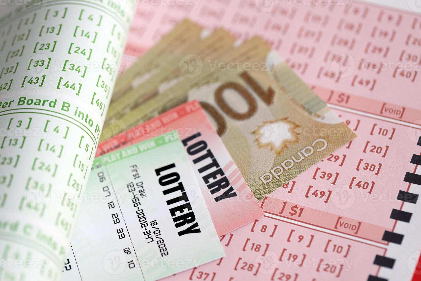 Lottery tickets lies with canadian dollars on gambling sheets with numbers for marking to play lottery photo