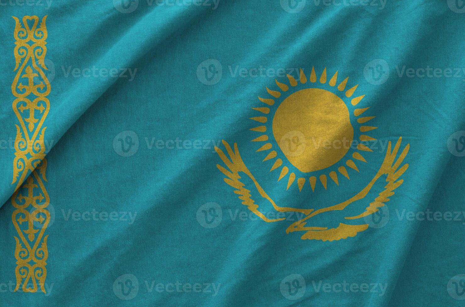 Kazakhstan flag depicted on folded wavy fabric of old cloth photo