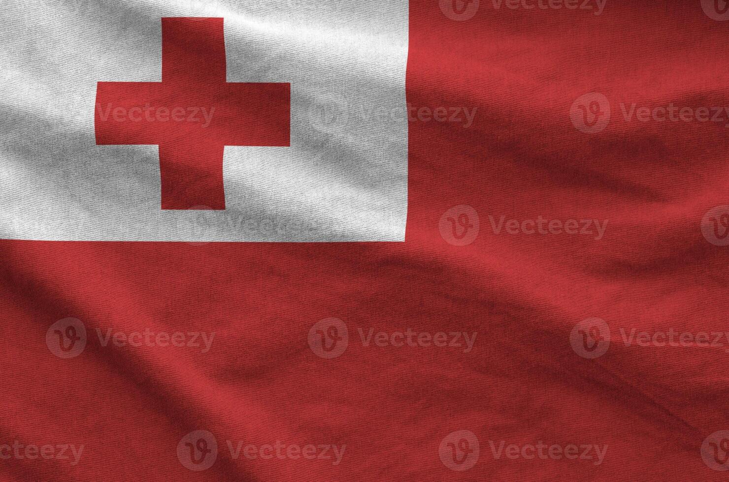 Tonga flag depicted on folded wavy fabric of old cloth photo