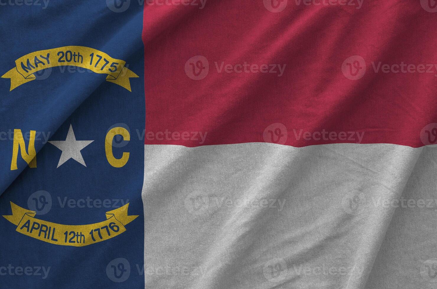 North Carolina US state flag depicted on folded wavy fabric of old cloth photo