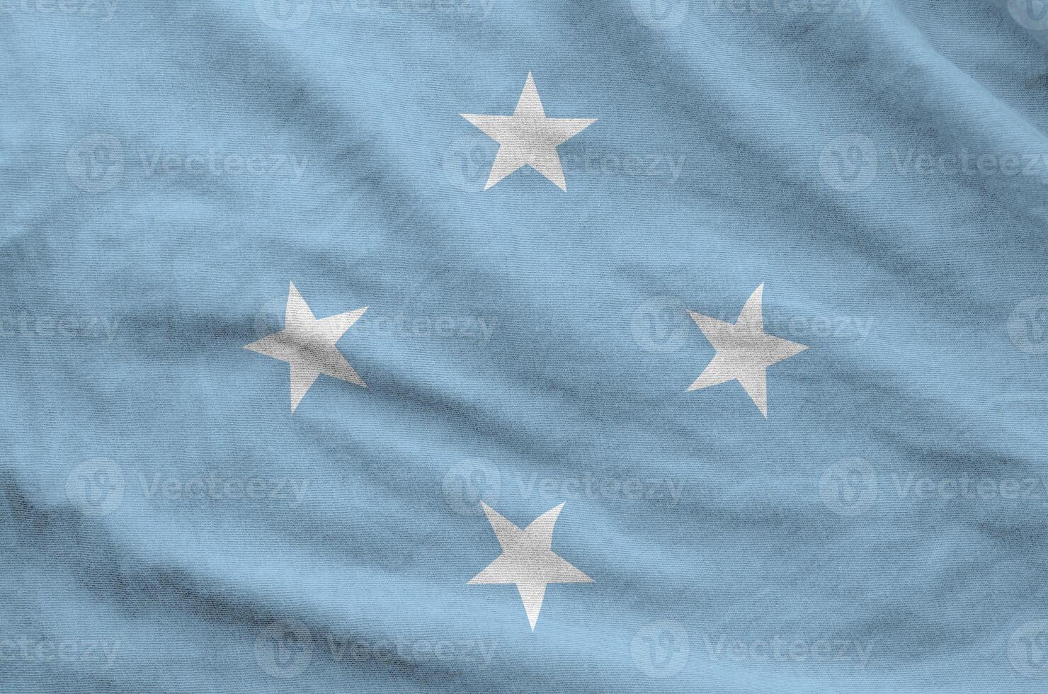 Micronesia flag depicted on folded wavy fabric of old cloth photo