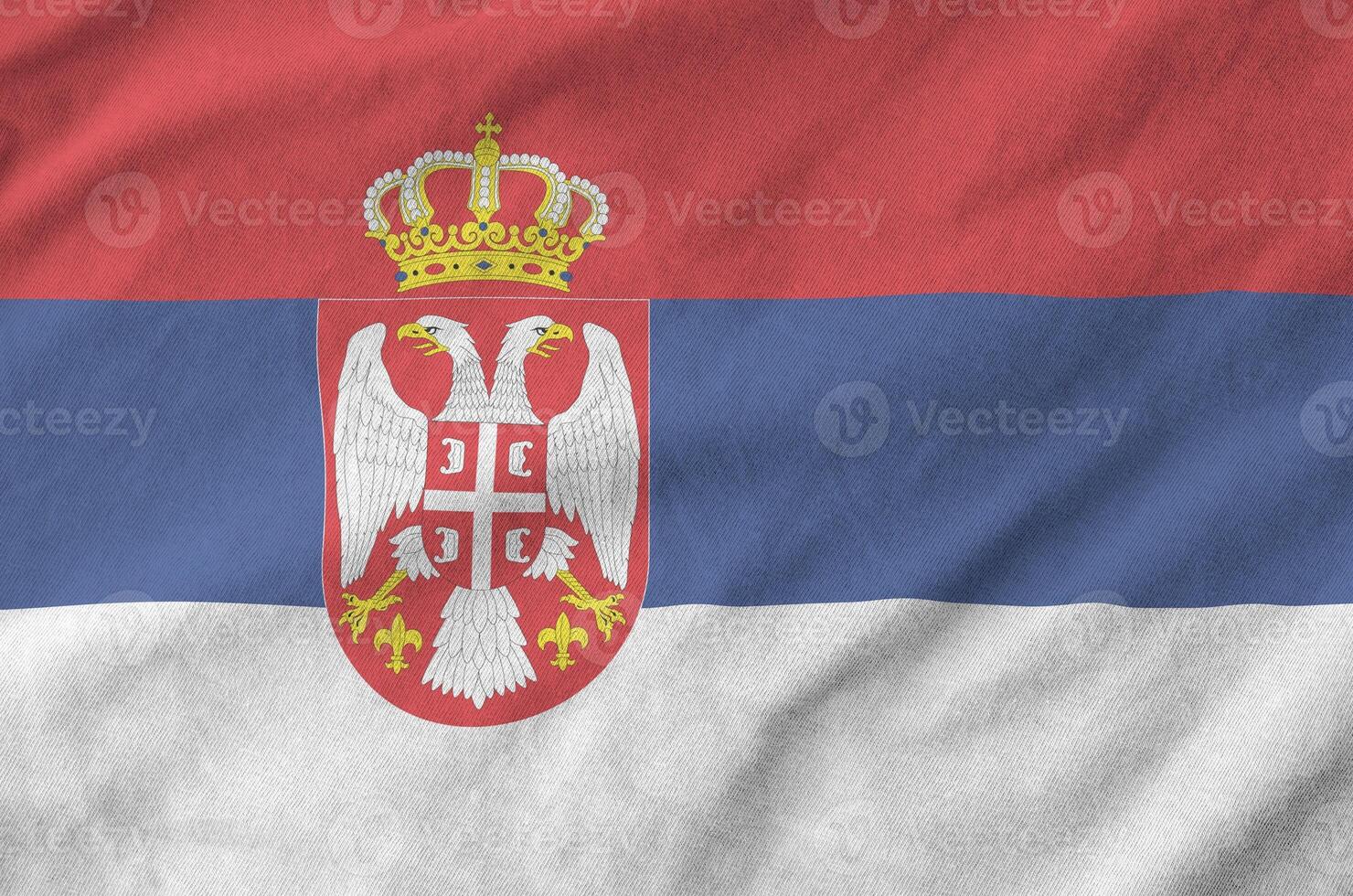 Serbia flag depicted on folded wavy fabric of old cloth photo