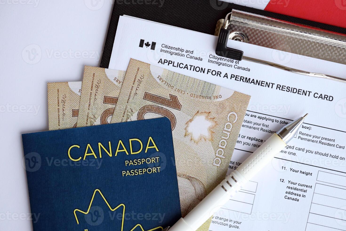Application for permanent resident card on table with pen and canadian passport with money photo