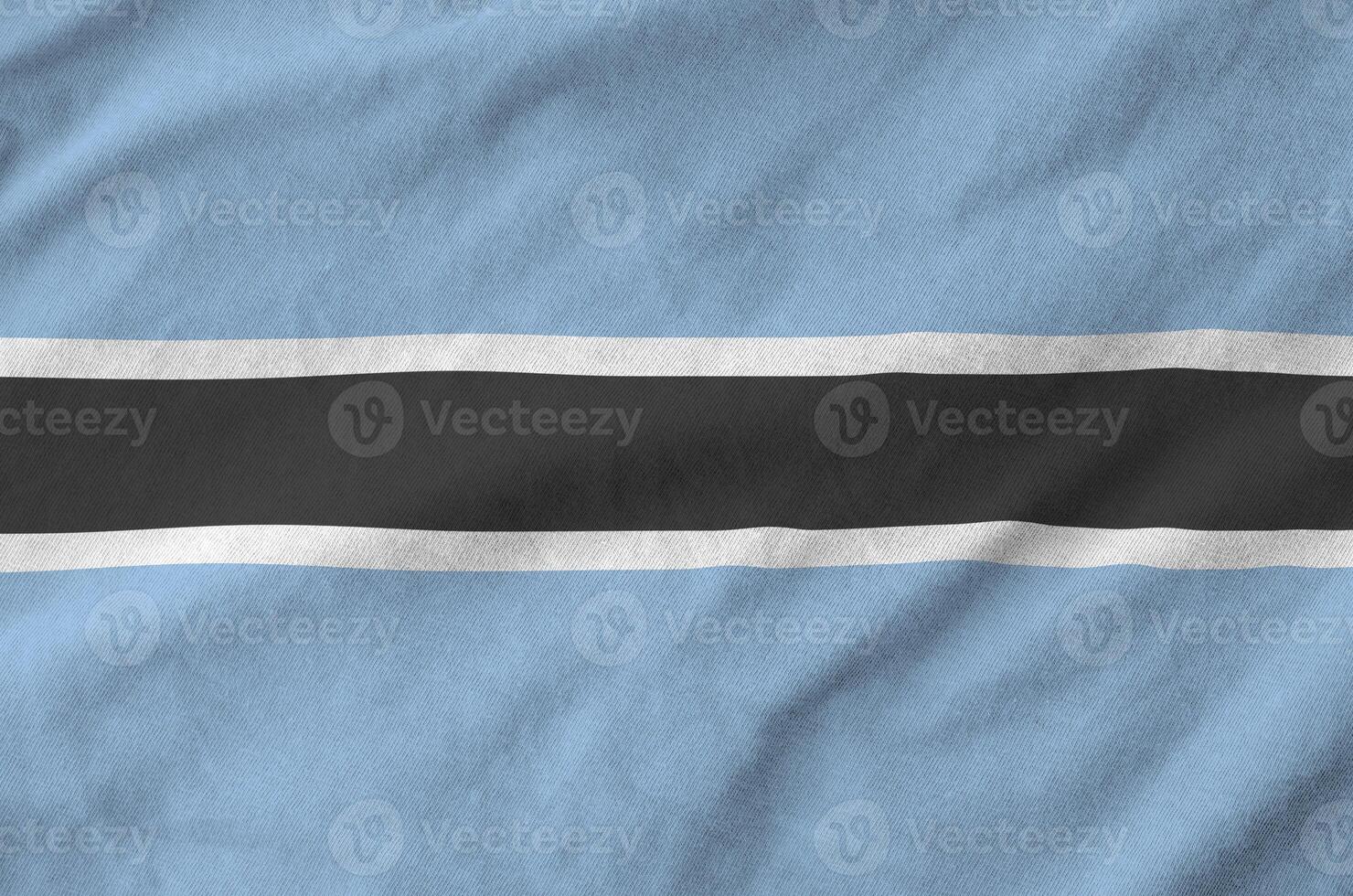 Botswana flag depicted on folded wavy fabric of old cloth photo