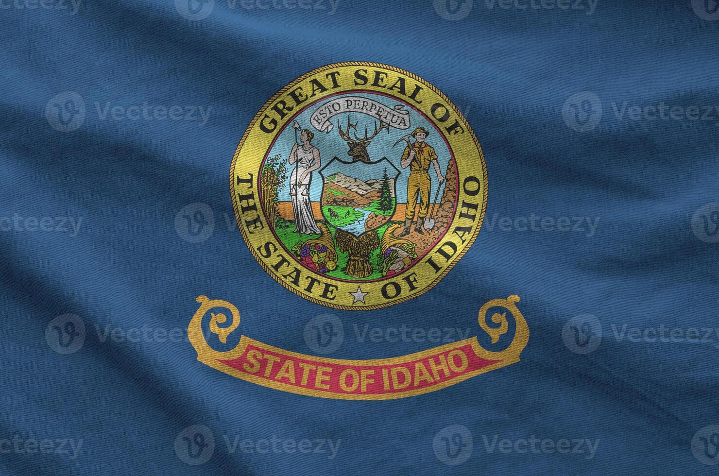 Idaho US state flag depicted on folded wavy fabric of old cloth photo
