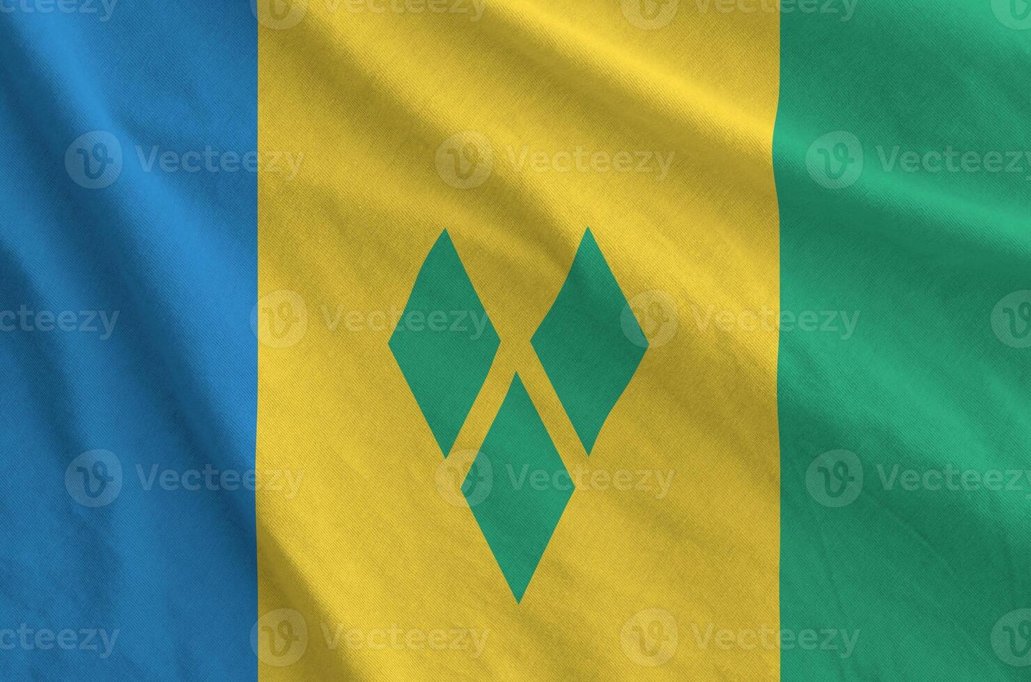Saint Vincent and the Grenadines flag depicted on folded wavy fabric of old cloth photo