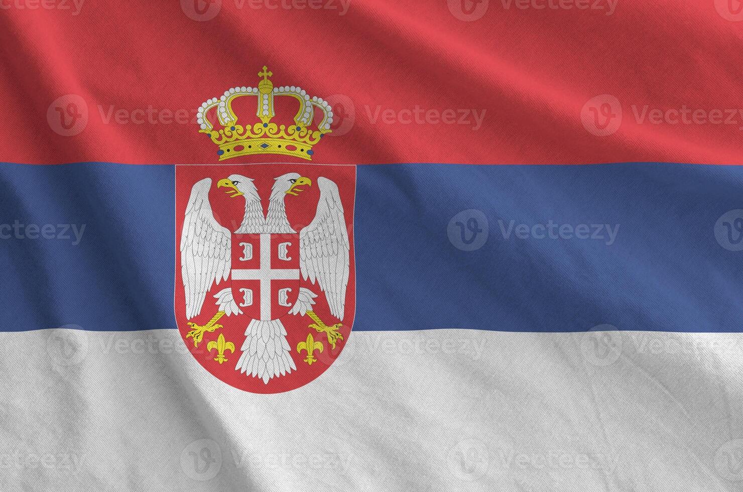 Serbia flag depicted on folded wavy fabric of old cloth photo