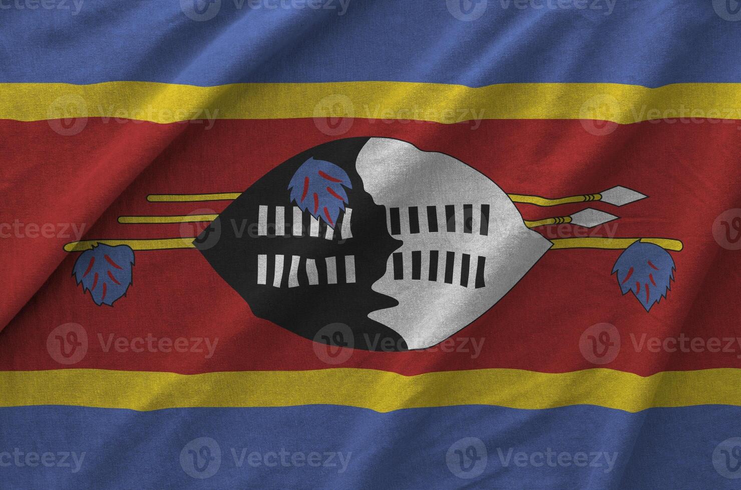 Swaziland flag depicted on folded wavy fabric of old cloth photo