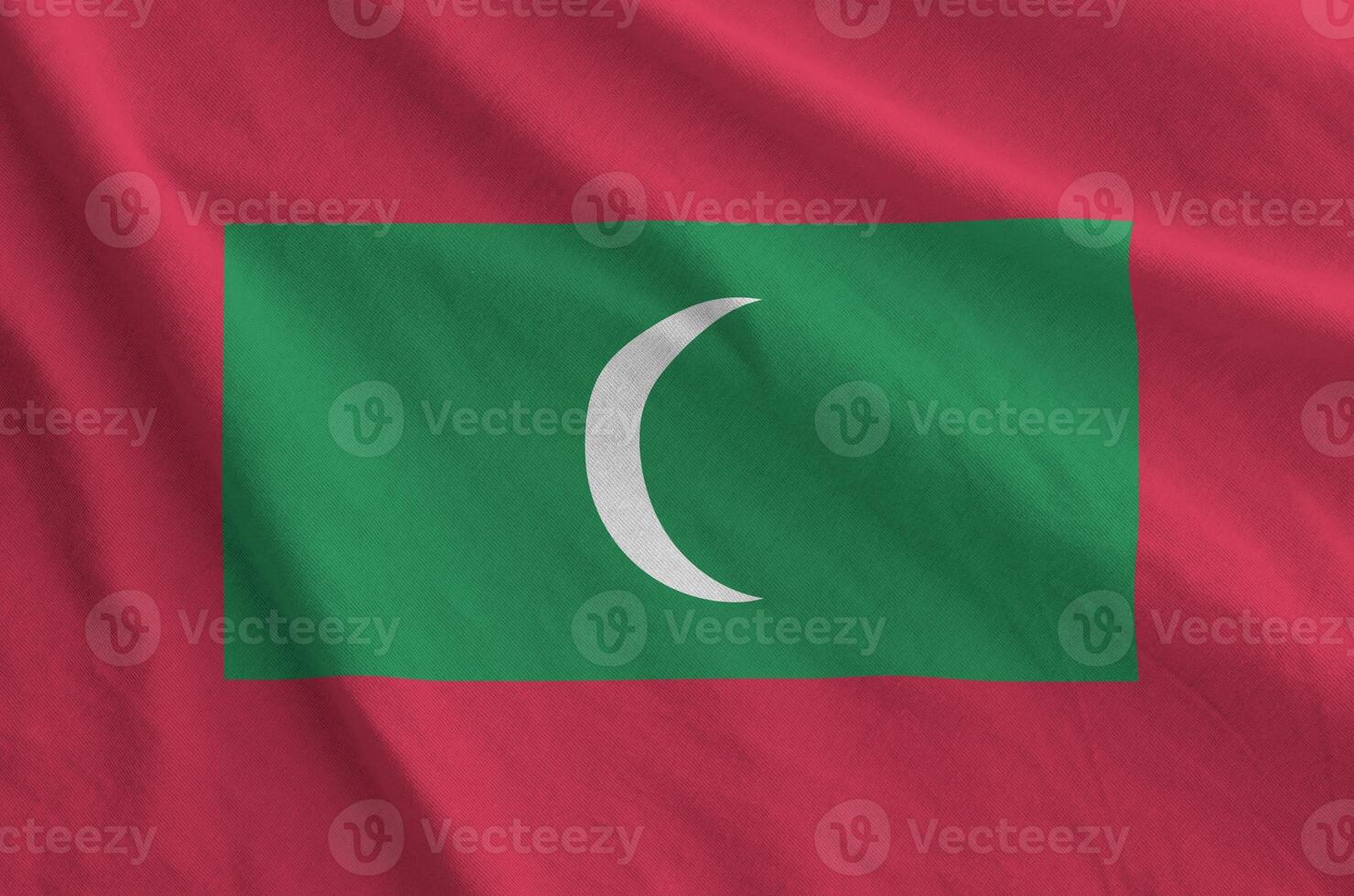 Maldives flag depicted on folded wavy fabric of old cloth photo