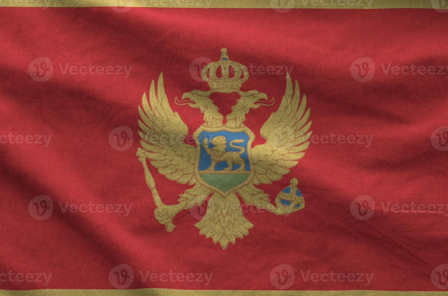 Montenegro flag depicted on folded wavy fabric of old cloth photo