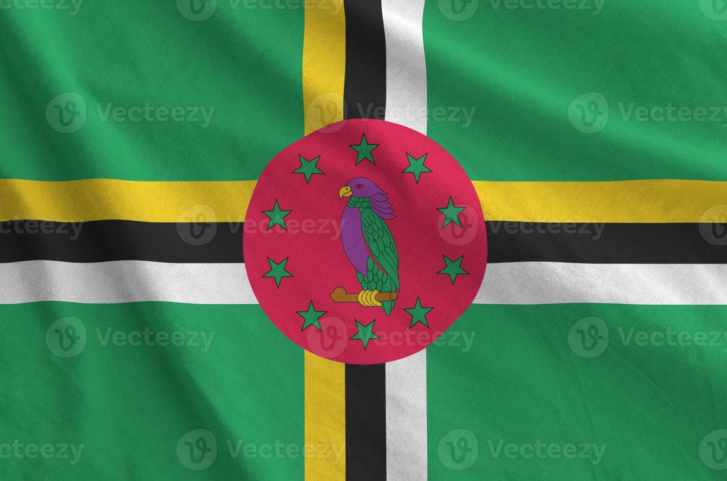 Dominica flag depicted on folded wavy fabric of old cloth photo