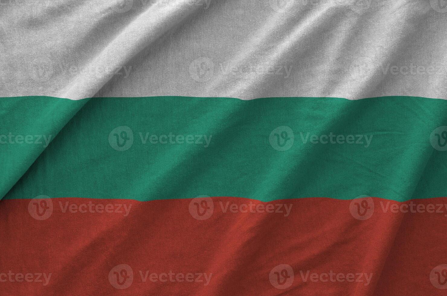 Bulgaria flag depicted on folded wavy fabric of old cloth photo