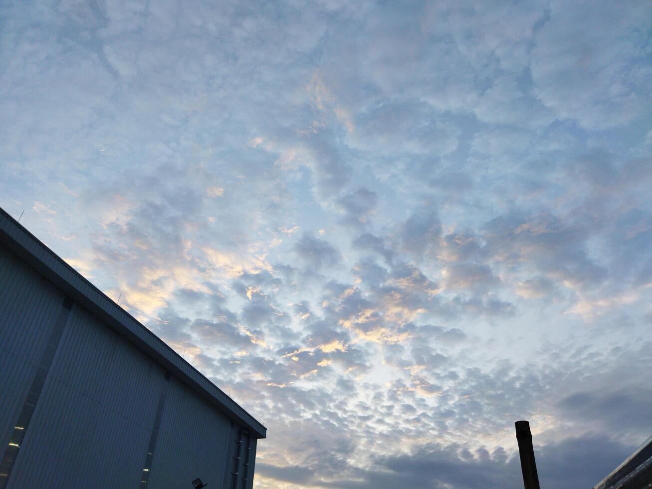 a view of the sky with clouds and a building photo