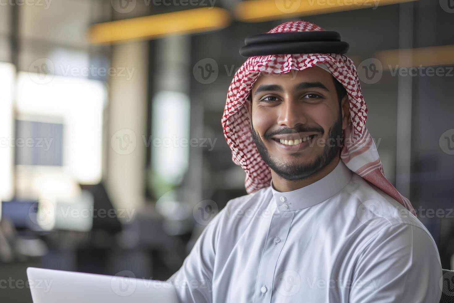A Attractive Smiling Arab Muslim Business Man Working in his Modern Office photo
