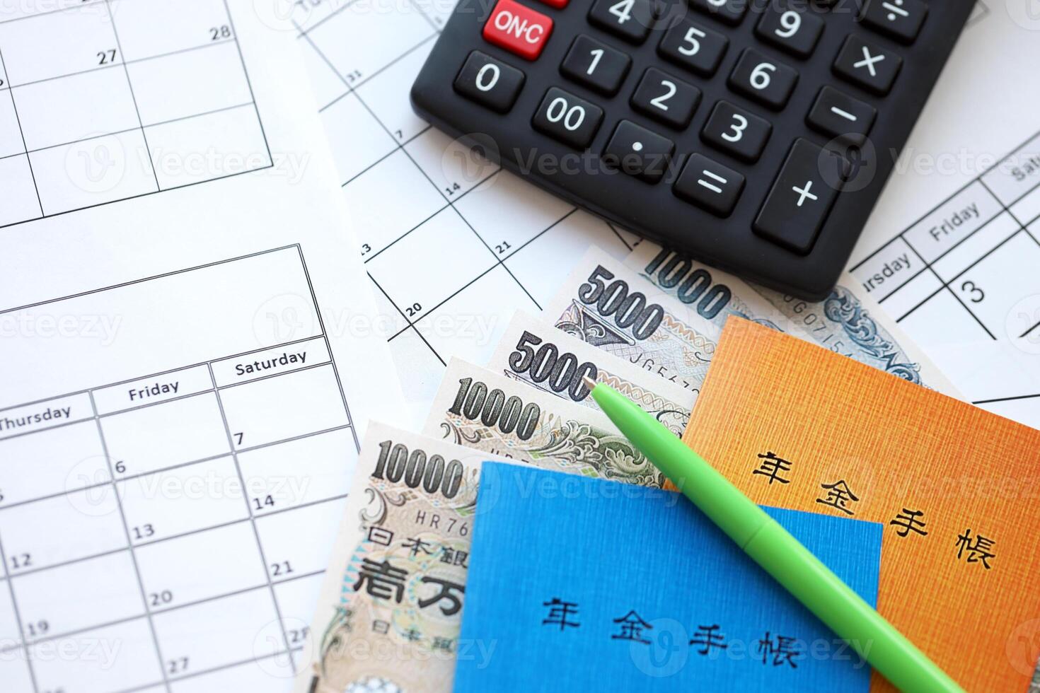 Japanese pension insurance booklets on table with yen money bills and calculator on table photo
