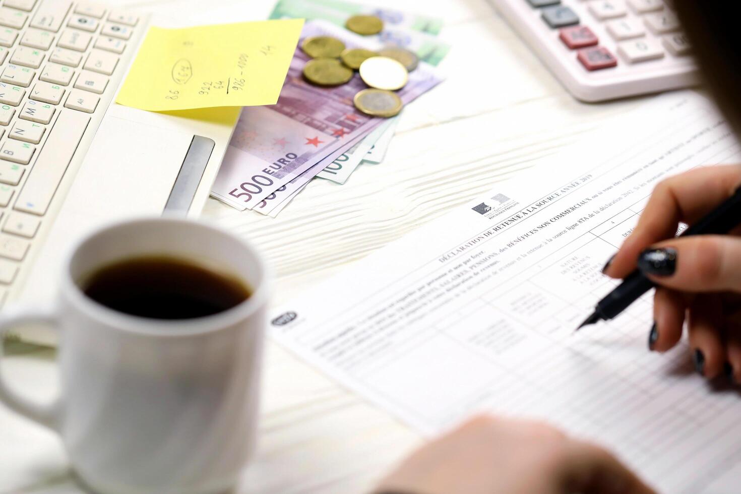 KYIV, UKRAINE - OCTOBER 31, 2023 Accountant fill french tax form 2041E Withholding tax declaration in end of tax period. Taxation and paperwork routine photo