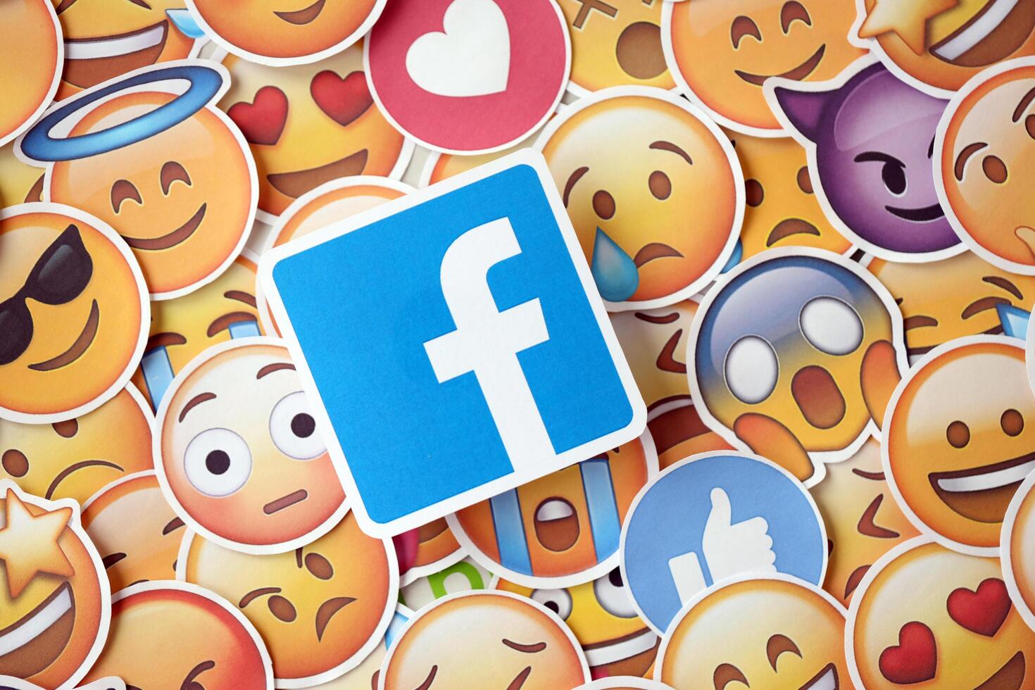 KYIV, UKRAINE - APRIL 20, 2024 Facebook logo and large set of stickers with Emoji yellow faces. Emoji is a pictogram or smiley embedded in text and used in electronic messages photo