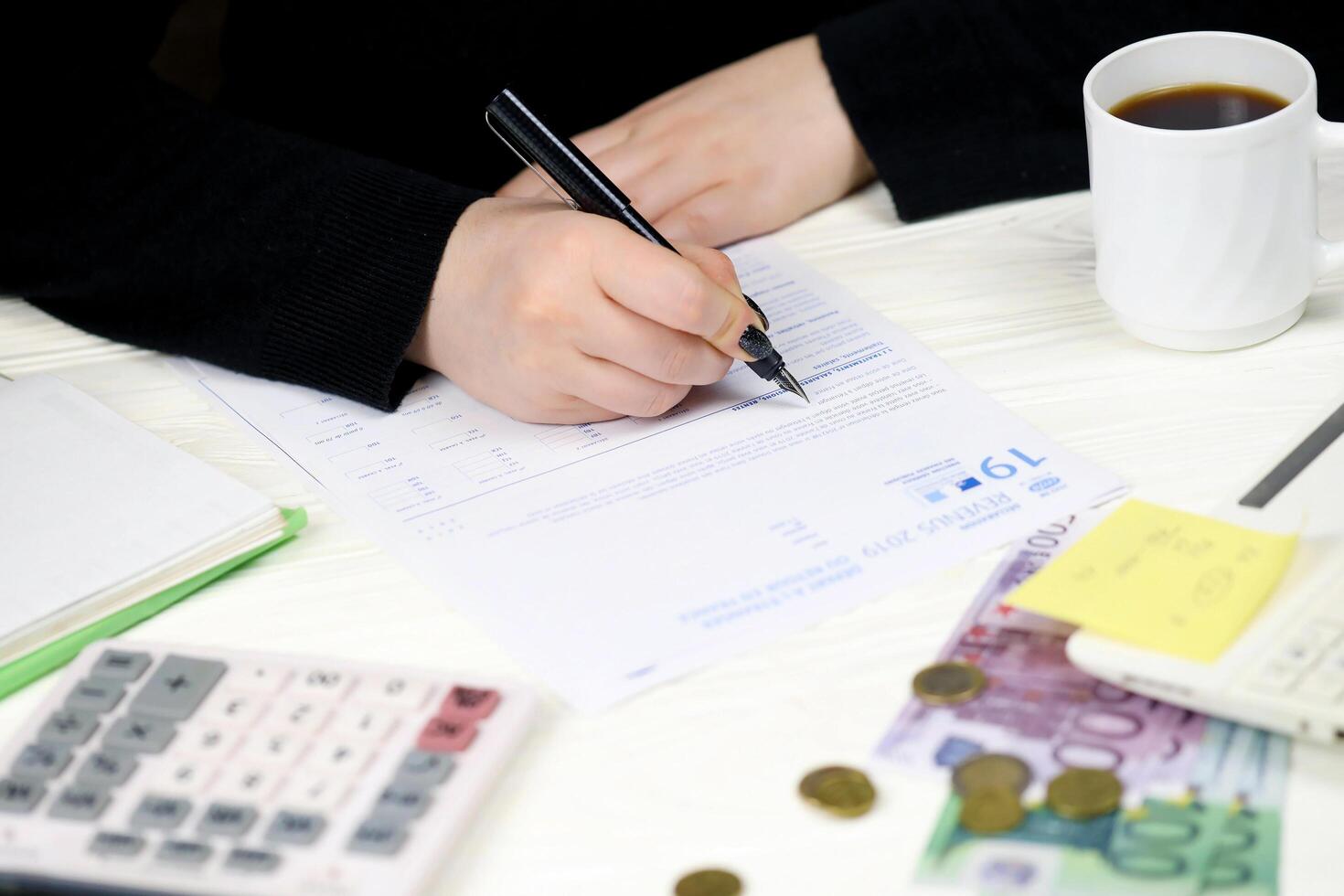 KYIV, UKRAINE - OCTOBER 31, 2023 Accountant fill french tax form 2042 NR departure abroad or return to France in end of tax period. Taxation and paperwork routine photo