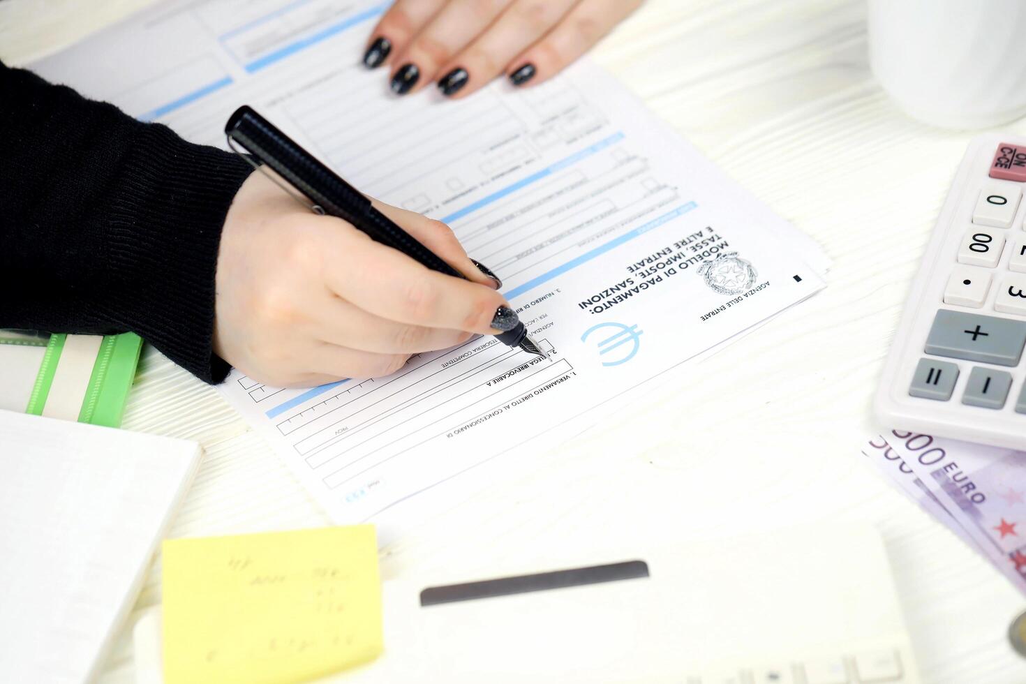 KYIV, UKRAINE - OCTOBER 31, 2023 Accountant fill italian tax form F23 Payment model taxes duties penalties and other revenues in end of tax period. Taxation and paperwork routine photo