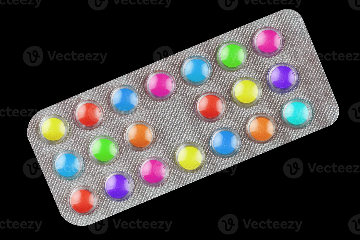 Multicolored vitamin pills in a transparent blister photo