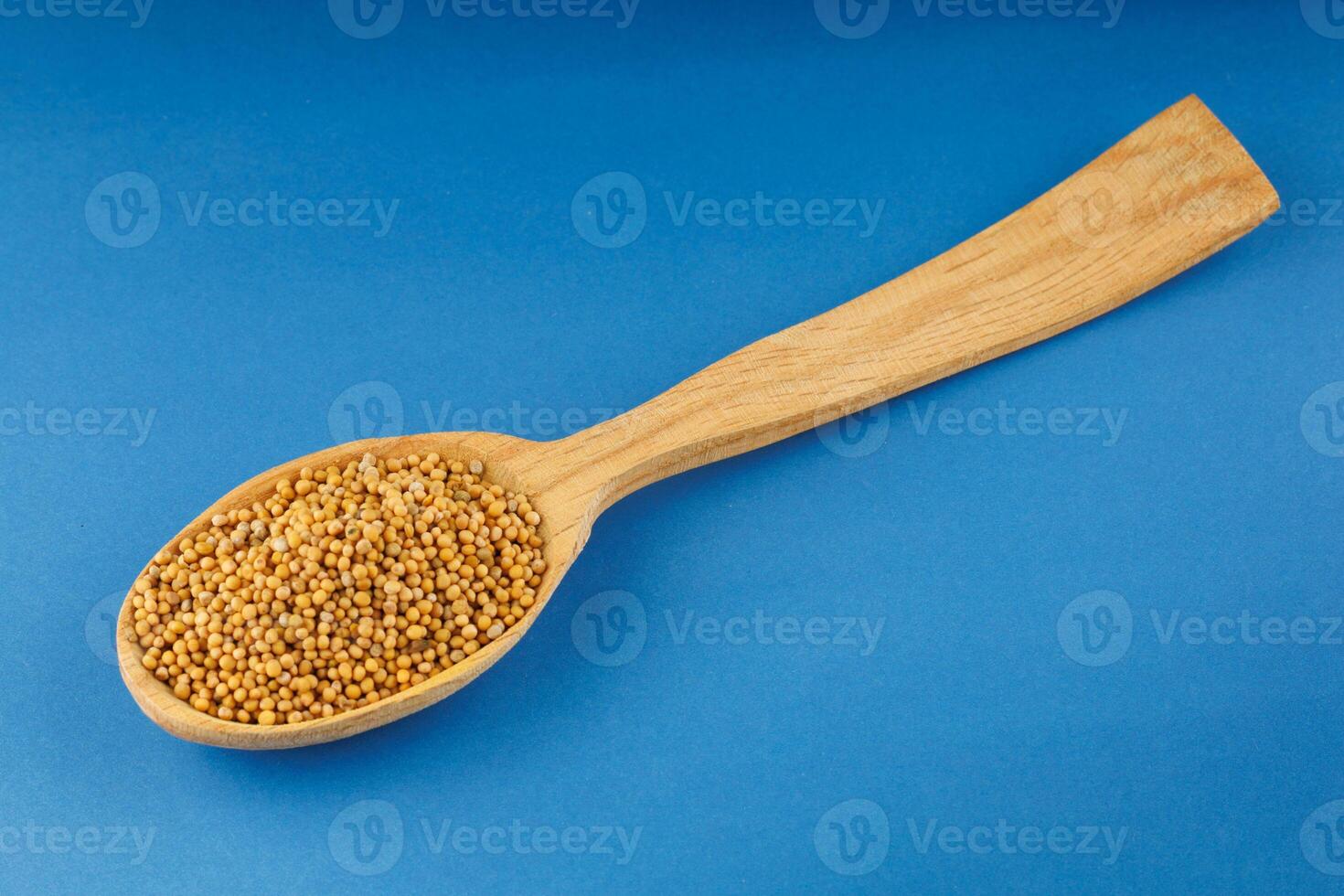 Millet in a wooden spoon on a blue background photo