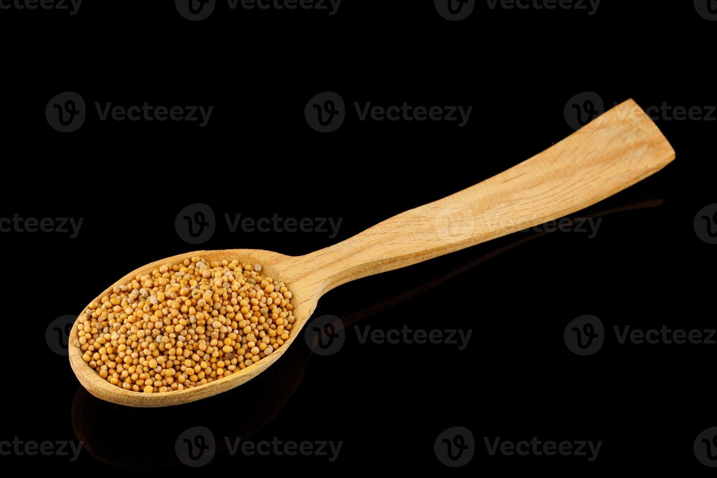 Millet in a wooden spoon on a black background photo