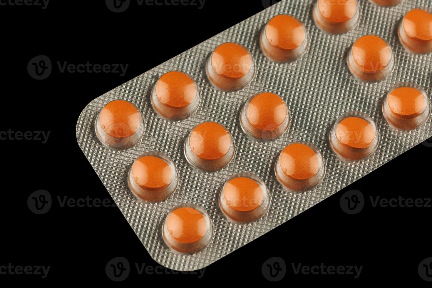 Orange pills in a transparent blister photo