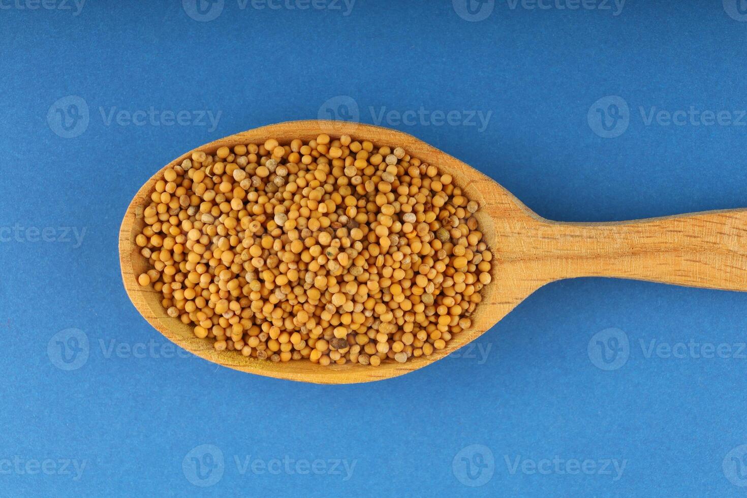 Millet in a wooden spoon on a blue background photo
