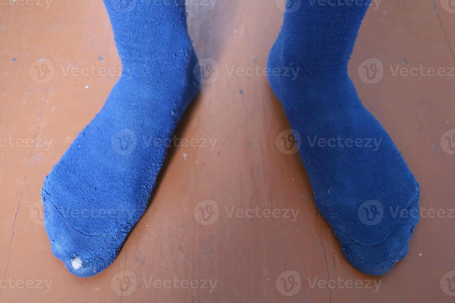The poor man in torn socks photo